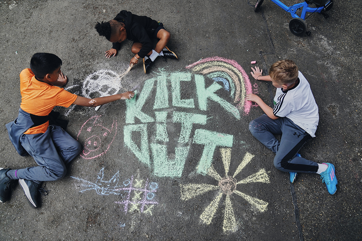 Kids drawing a chalk logo