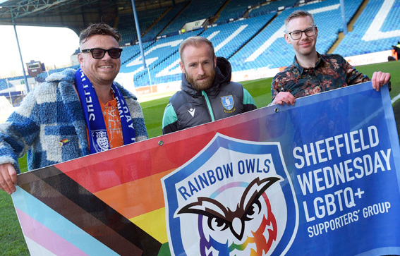 Rainbow Owls members holding the group banner with Barry Bannan
