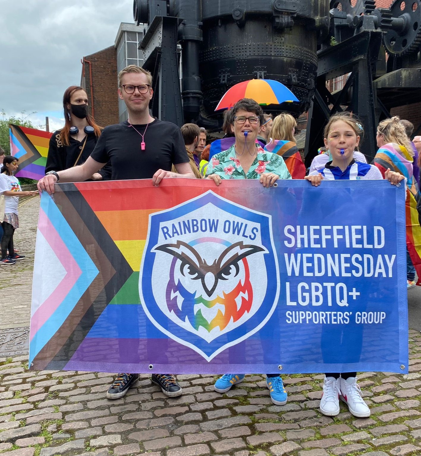 Rainbow Owls members holding the group banner before marching in the Kelham Pride parade on Saturday 1 June.